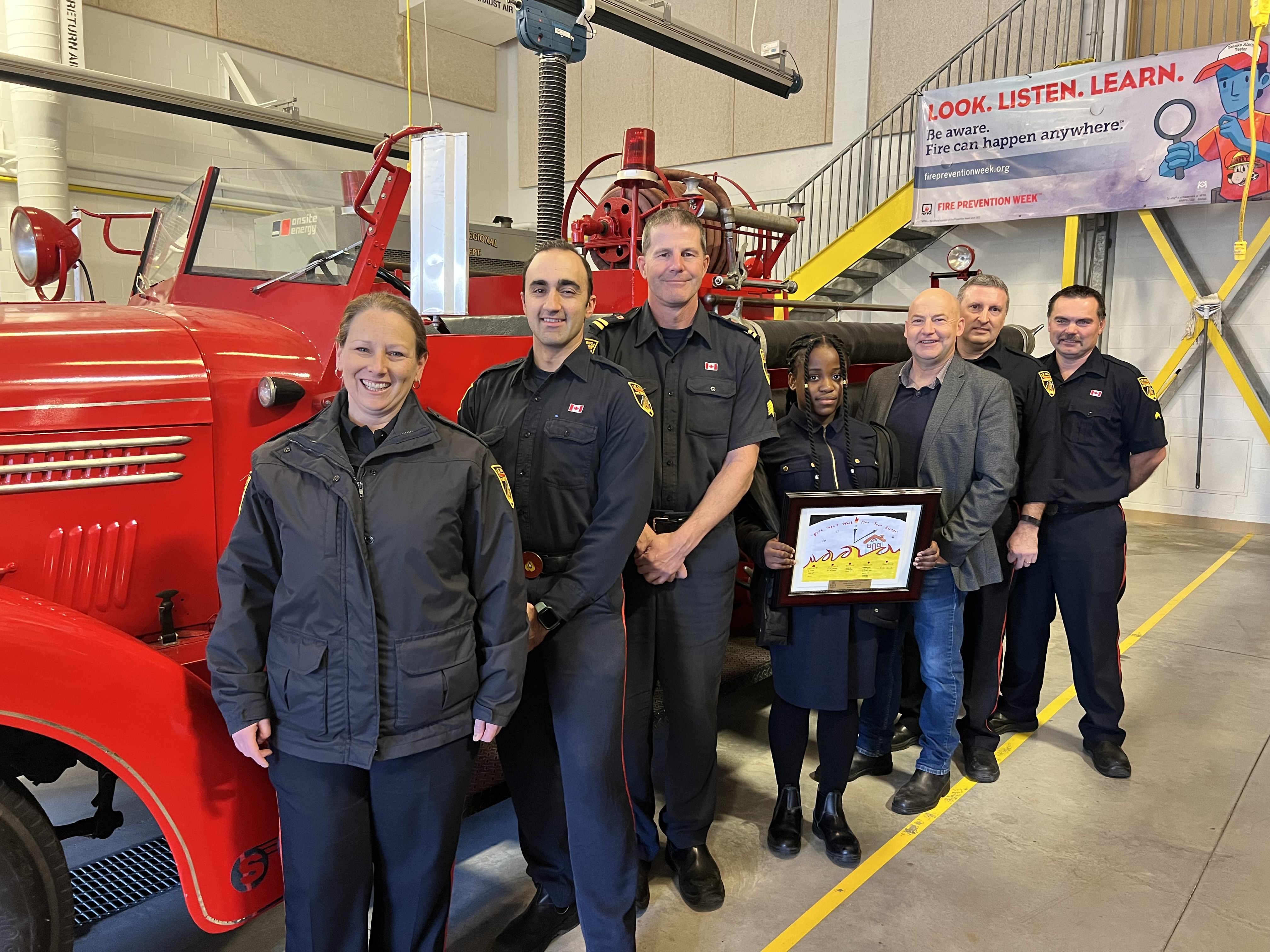 Paradise Fire Station No 8 photo with firefighters, fire truck and girl displaying her poster